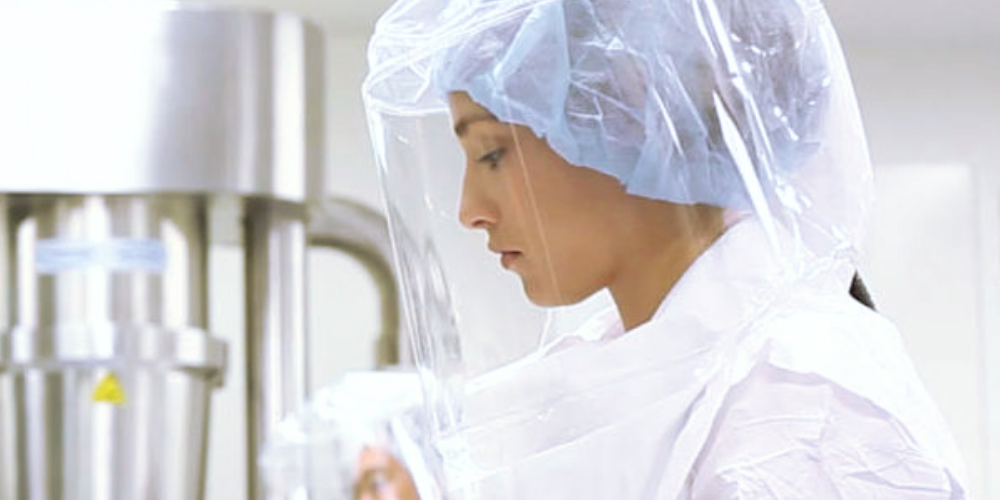 Pharmaceutical professional wears ILC Dover's Sentinel Clear Powered Air-Purifying Respirator (PAPR) system for protection