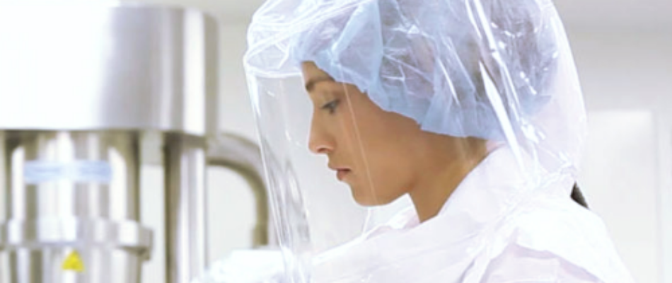 Biomanufacturing professional wearing the Sentinel Clear Powered Air-Purifying Respirator (PAPR) system for protection